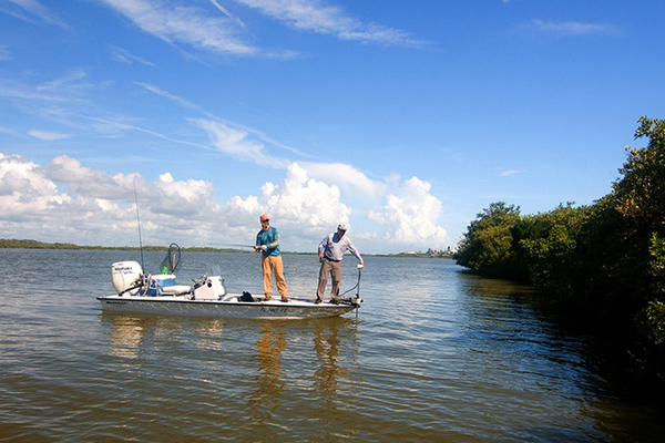 2 Men fishing in river on boat